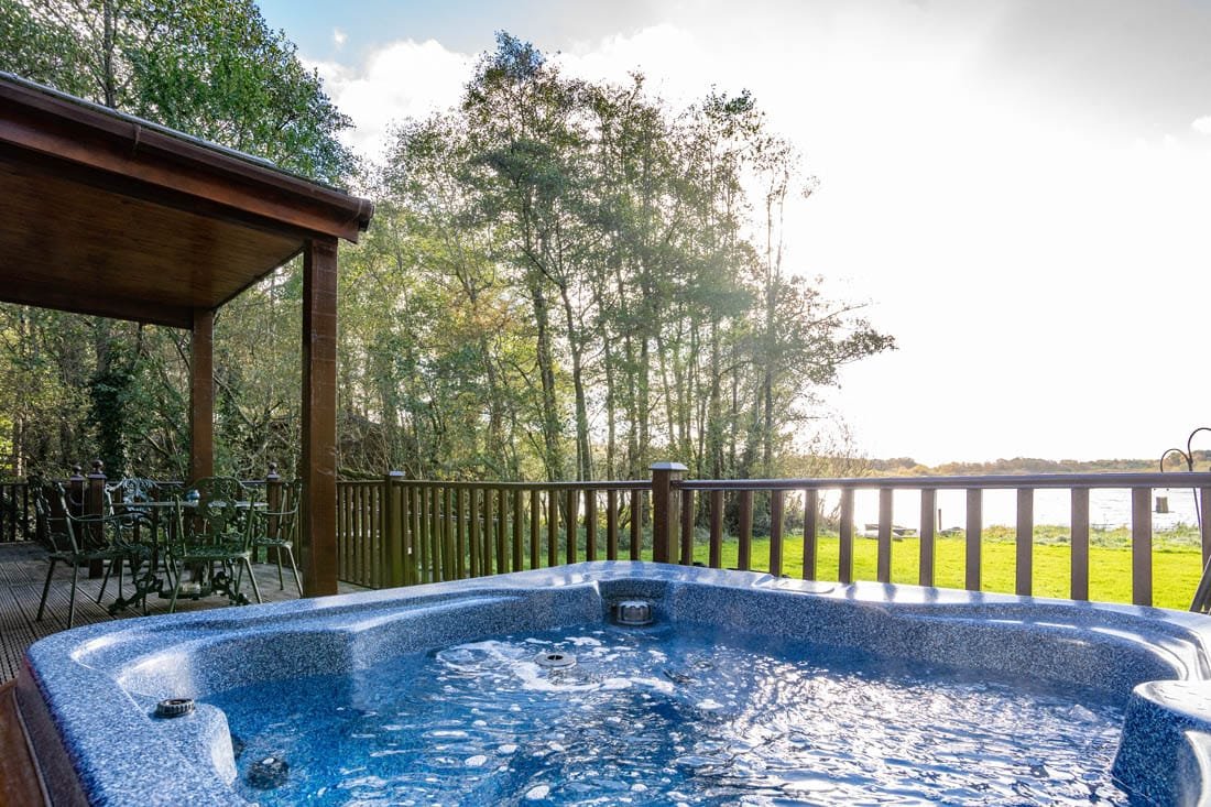 Outdoor jacuzzi overlooking forest and river.