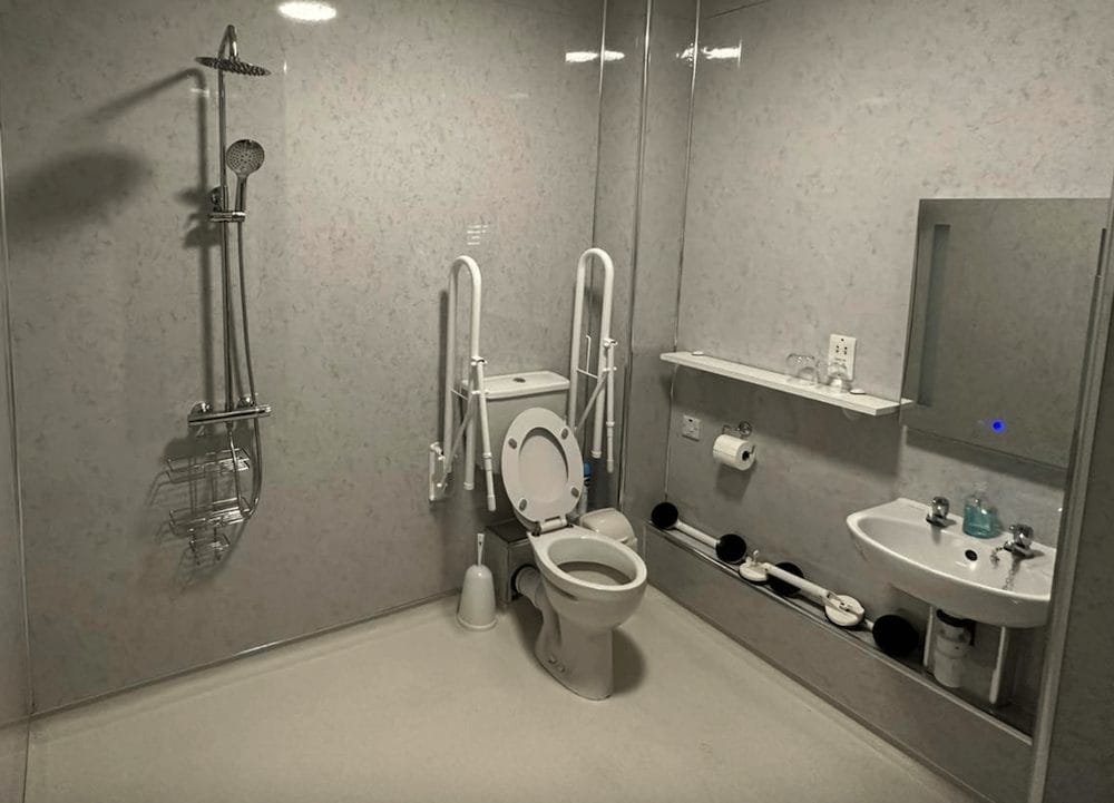 Accessible bathroom with safety handrails and shower.