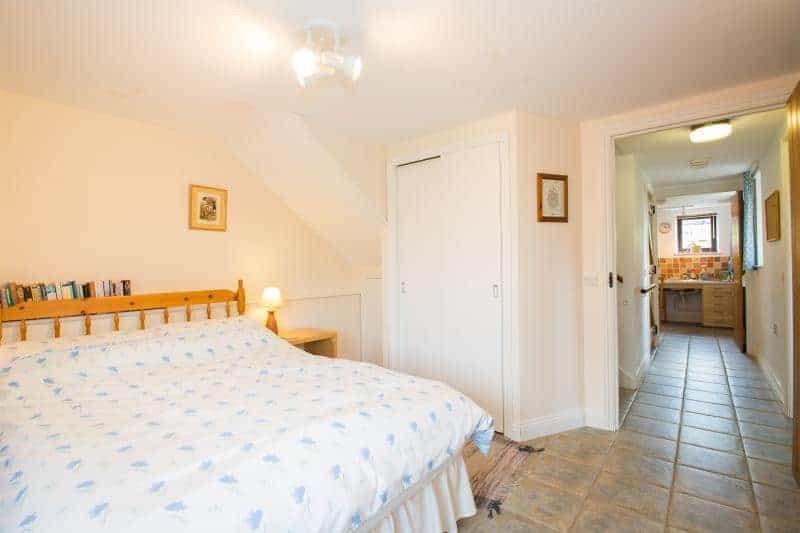 Bright bedroom with large bed and open doorway