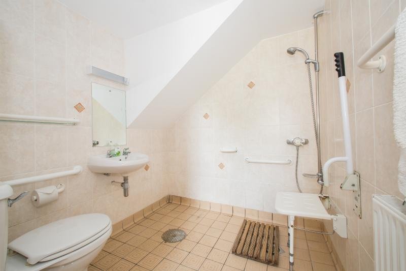 Accessible bathroom with beige tiles and safety features