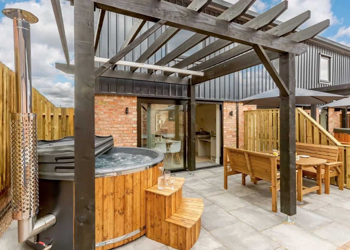 Outdoor hot tub with wooden deck and modern pergola
