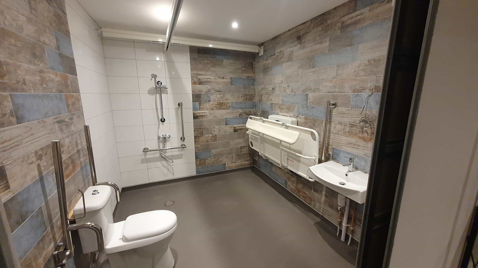 Modern accessible bathroom with shower and wall-mounted sink