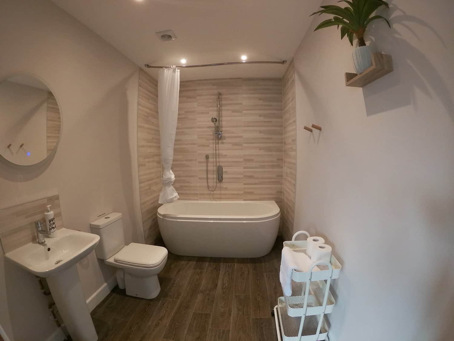 Modern bathroom with tub, shower, and wooden accents