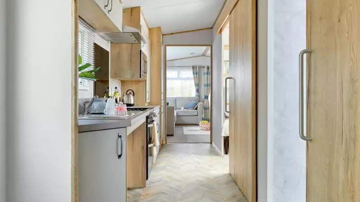 Bright modern kitchen leading to cozy living area