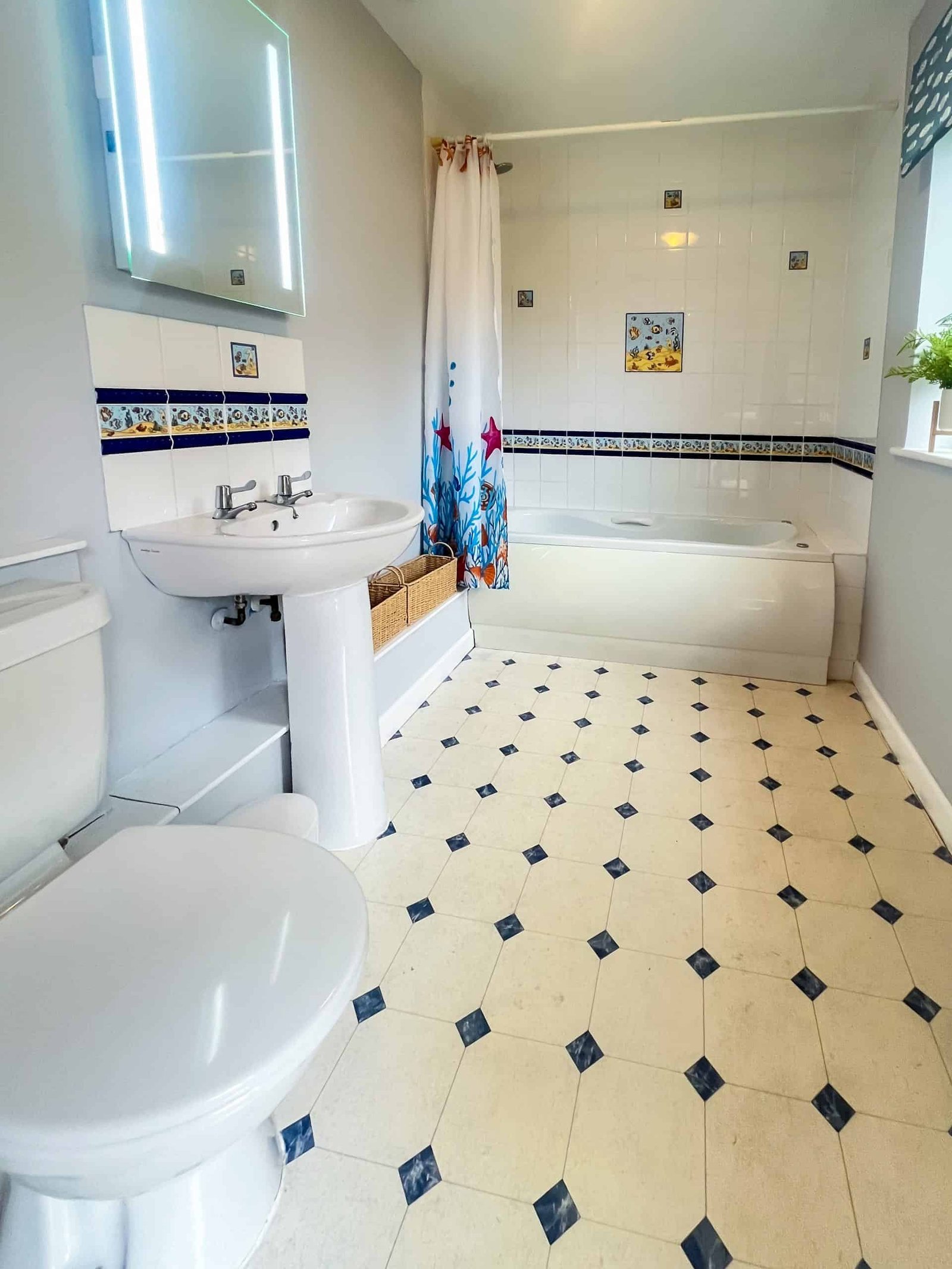 Bright bathroom with tiled floor and decorative curtain