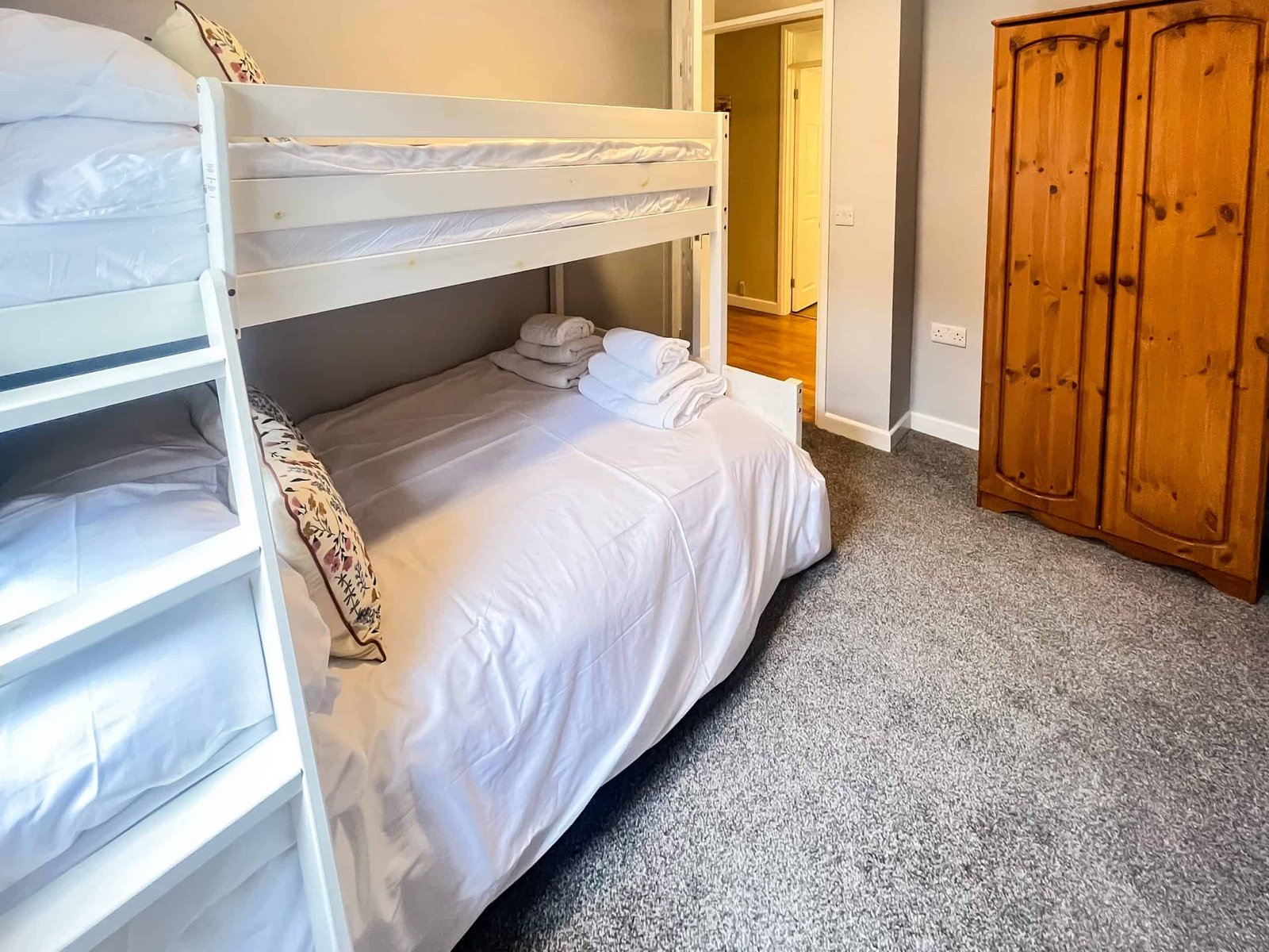 Cozy bedroom with white bunk bed and wooden wardrobe