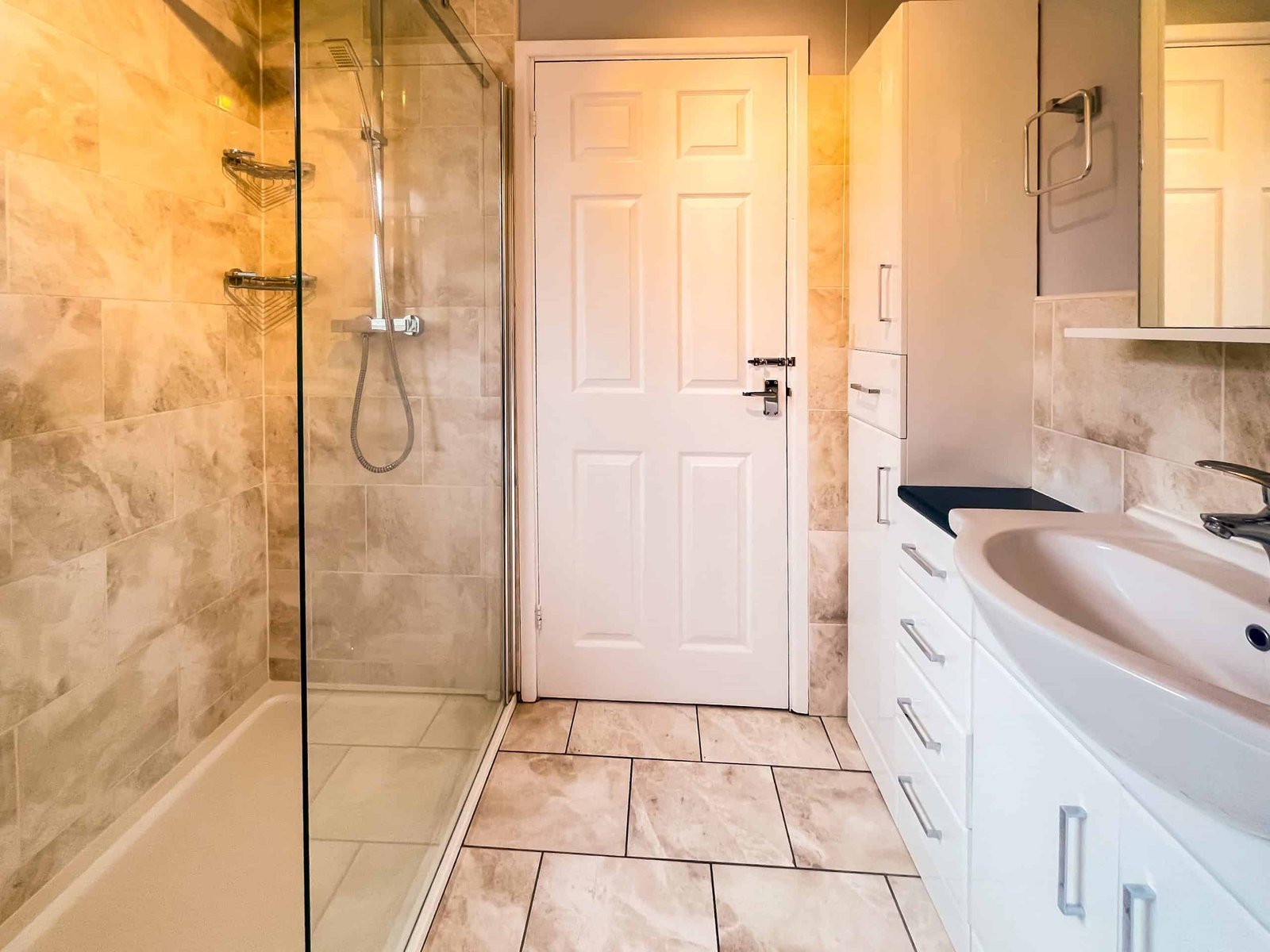 Modern bathroom with glass shower and white cabinets