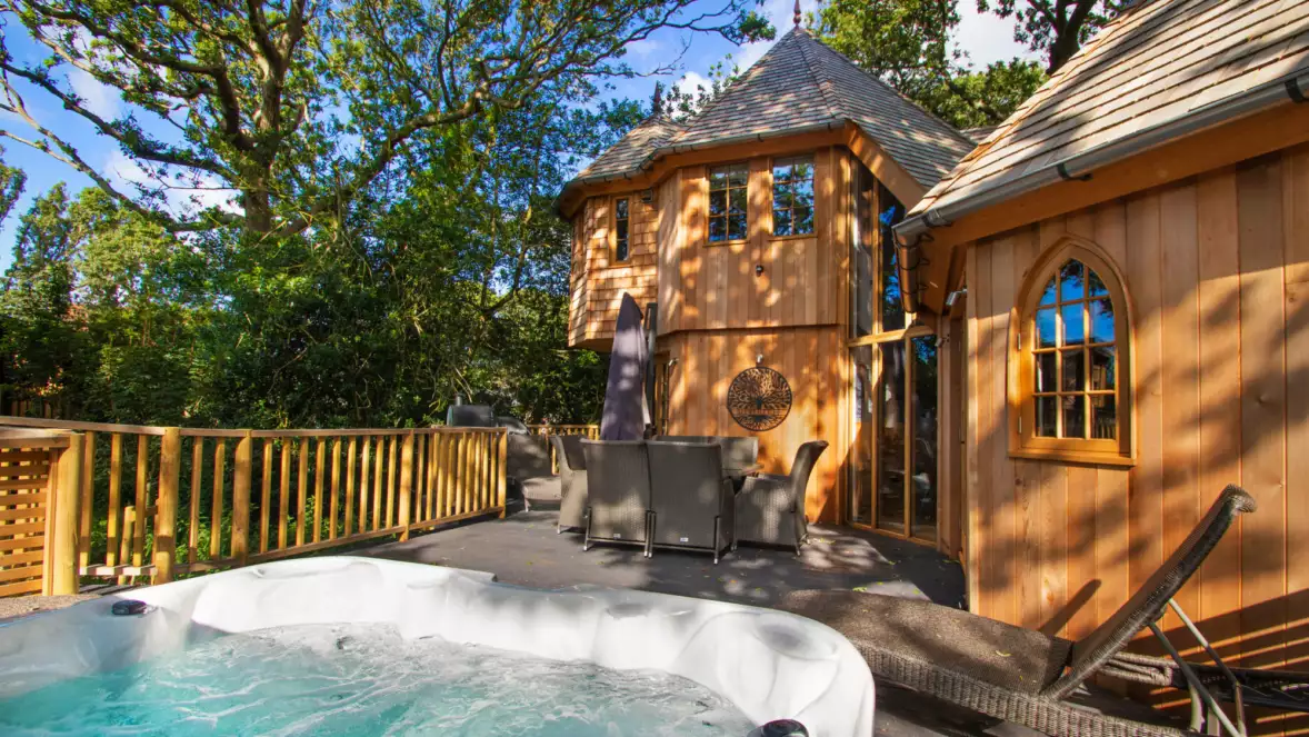 Wooden treehouse with hot tub surrounded by trees