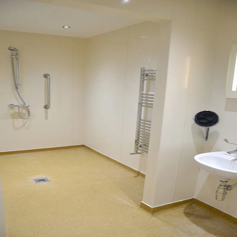 Accessible bathroom with safety rails and beige decor