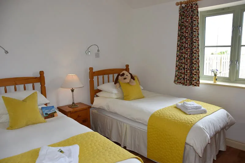 Bright twin bedroom with yellow accents and plush dog