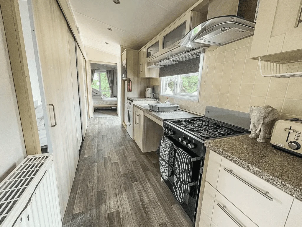 Narrow kitchen with modern appliances and wooden floor