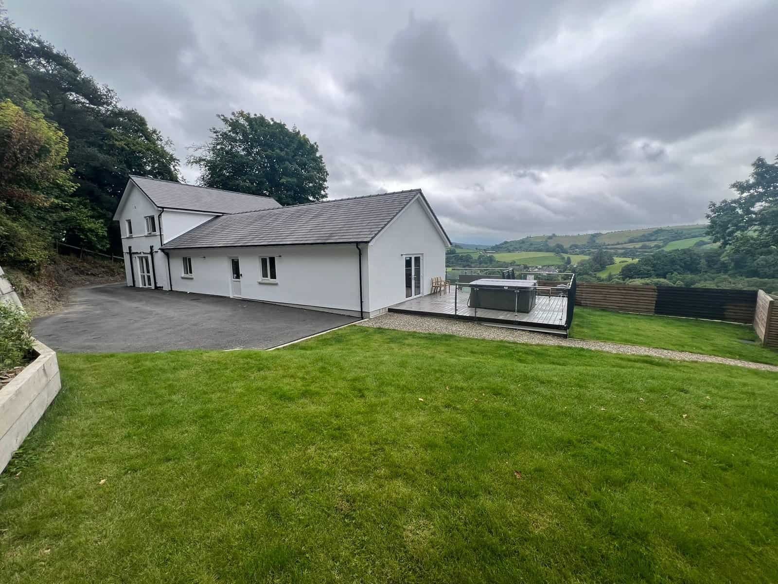 Modern house with green lawn and scenic hills backdrop