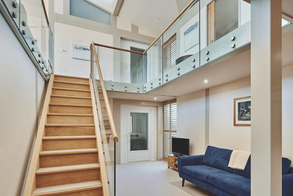 Modern interior with wooden staircase and glass balustrade