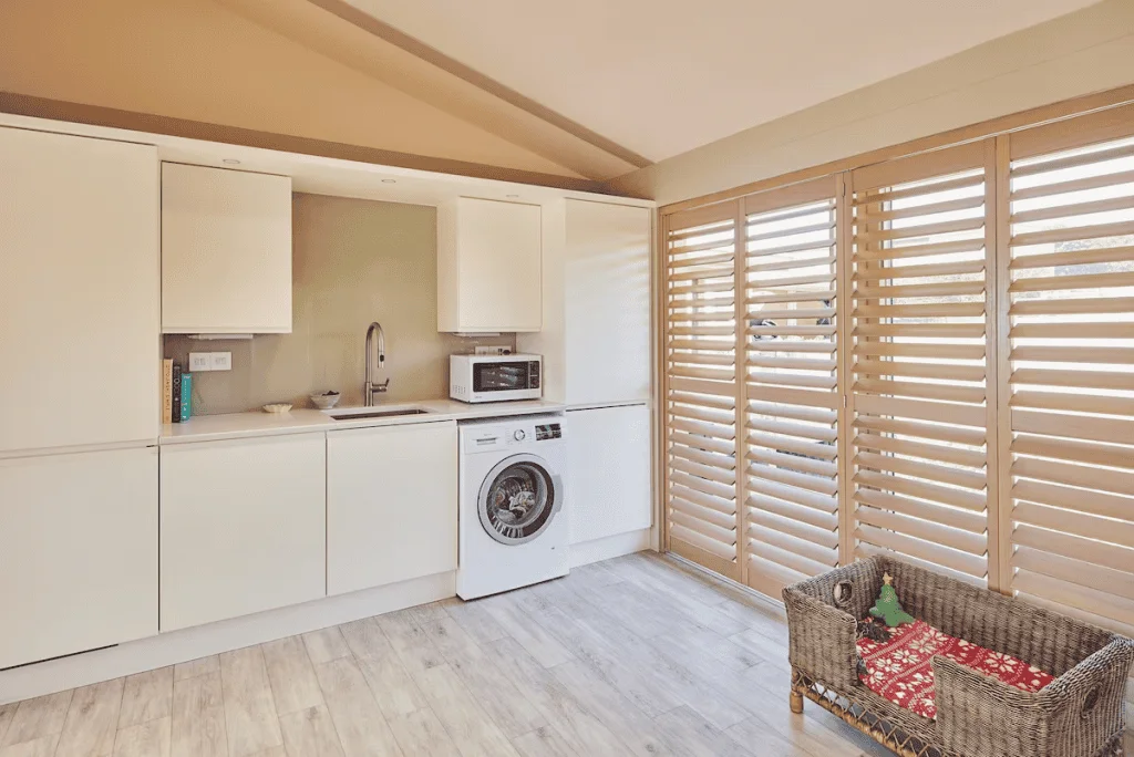 Modern kitchen interior with wooden blinds and wicker sofa