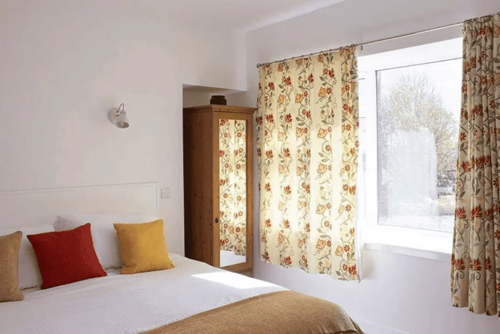 Bright bedroom with floral curtains and colorful pillows