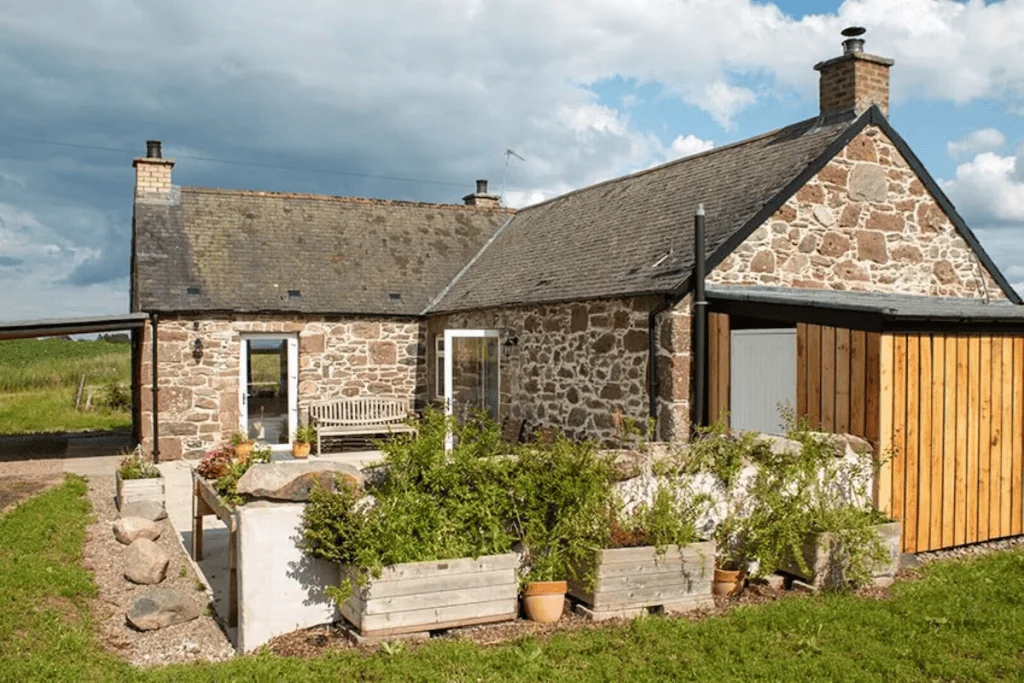 Charming stone cottage with lush garden and sunny skies