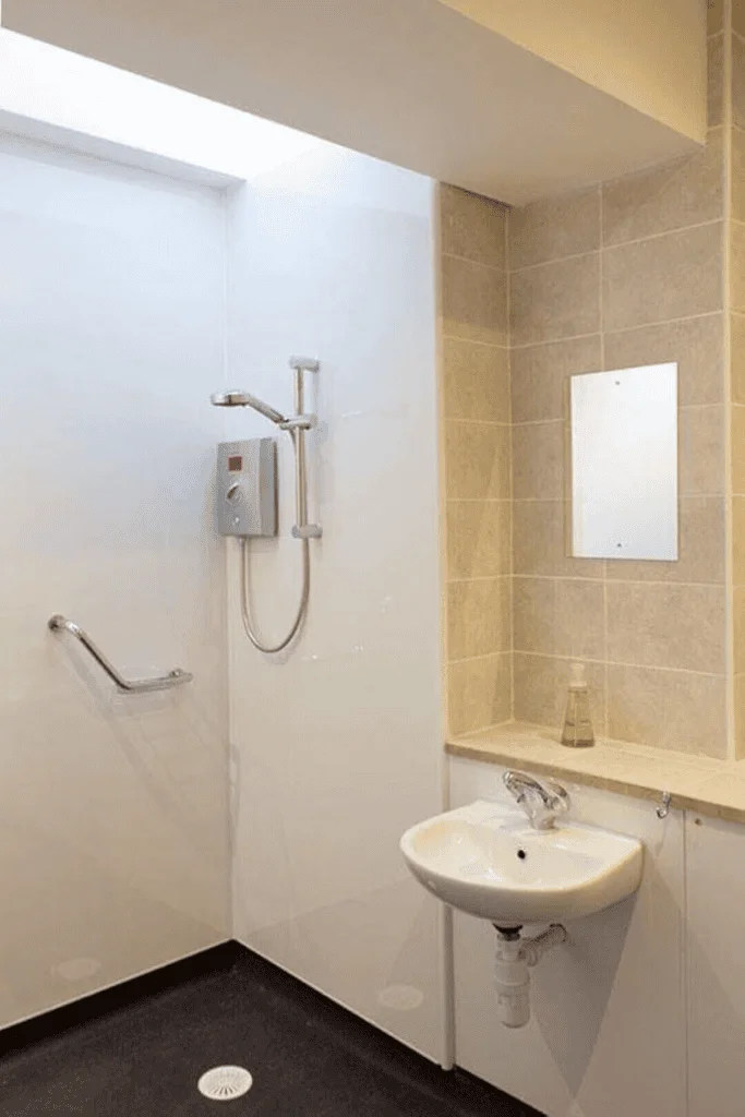 Modern accessible bathroom with handrails and light decor