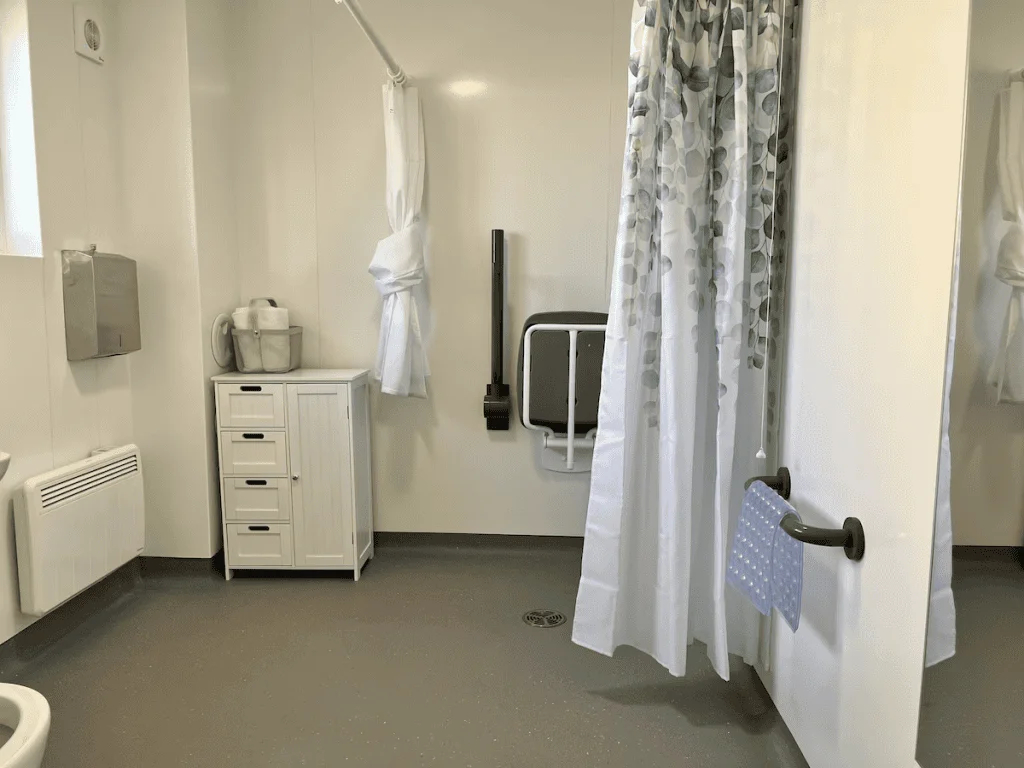 Clean hospital bathroom with privacy curtain and amenities