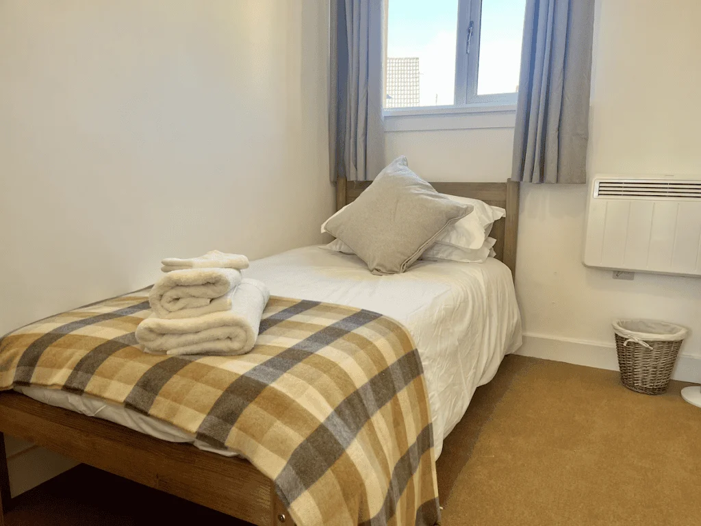 Cozy bedroom with plaid blanket and city view window
