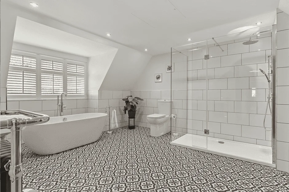 Modern bathroom with tub, shower, and patterned floor.