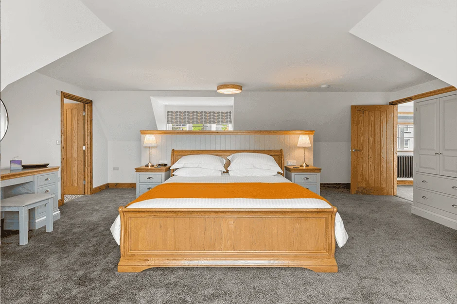 Spacious modern bedroom with wooden furniture and carpet