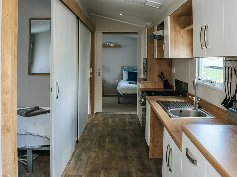 Compact modern kitchen leading to cozy bedroom