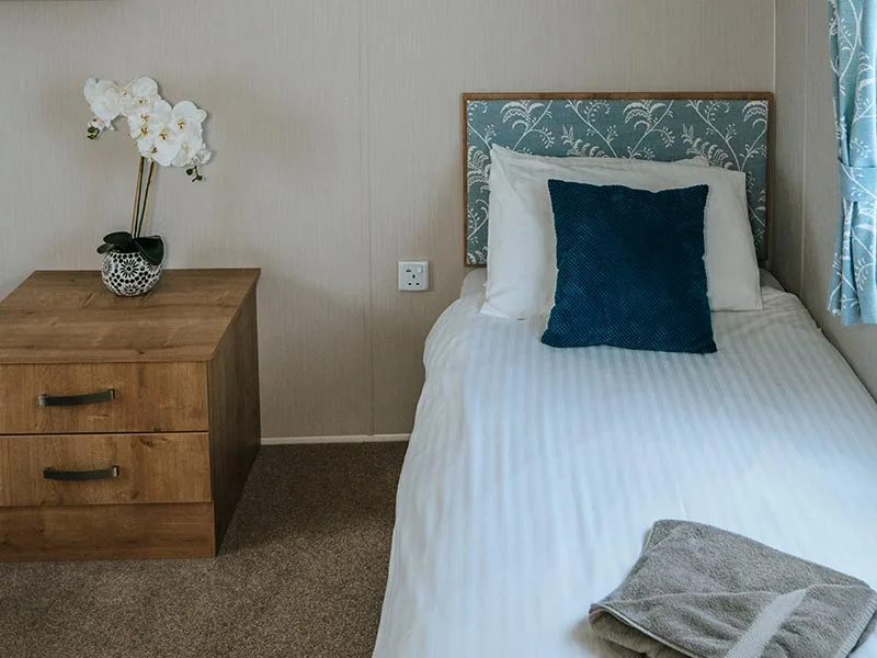 Cozy bedroom with white bedding and wooden nightstand
