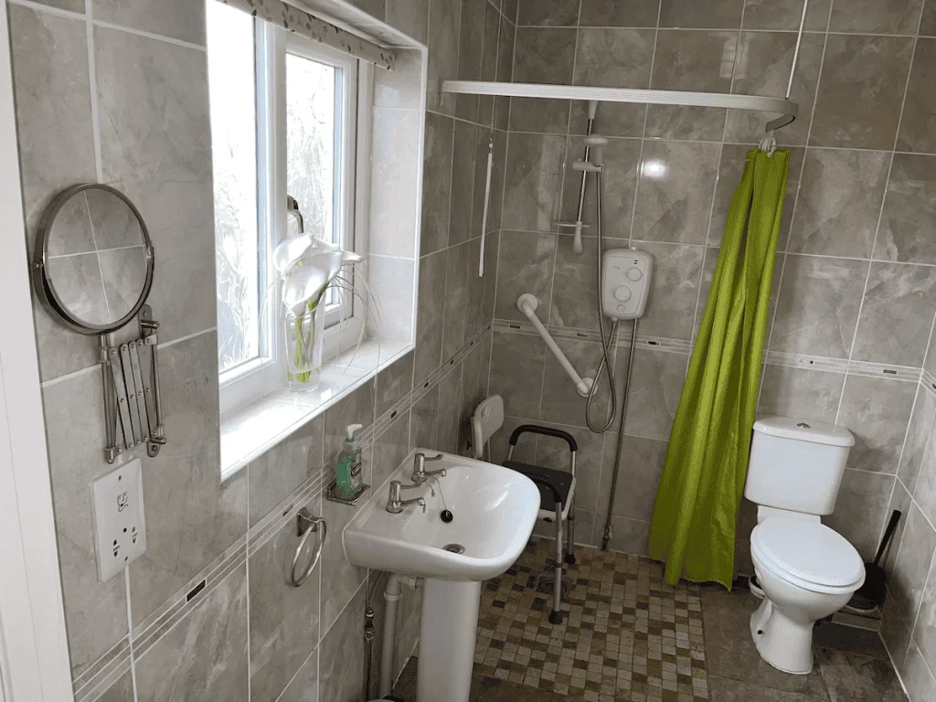 Modern bathroom with grey tiles and green shower curtain
