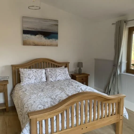Bright bedroom with wooden bed and ocean-themed artwork