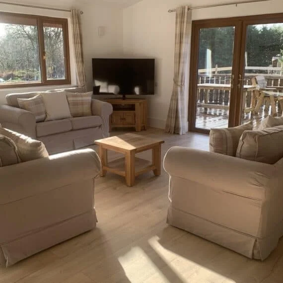 Sunny living room with sofas and deck view