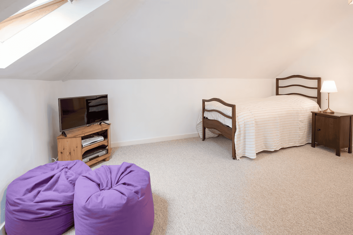 Cozy attic bedroom with twin bed and purple bean bags