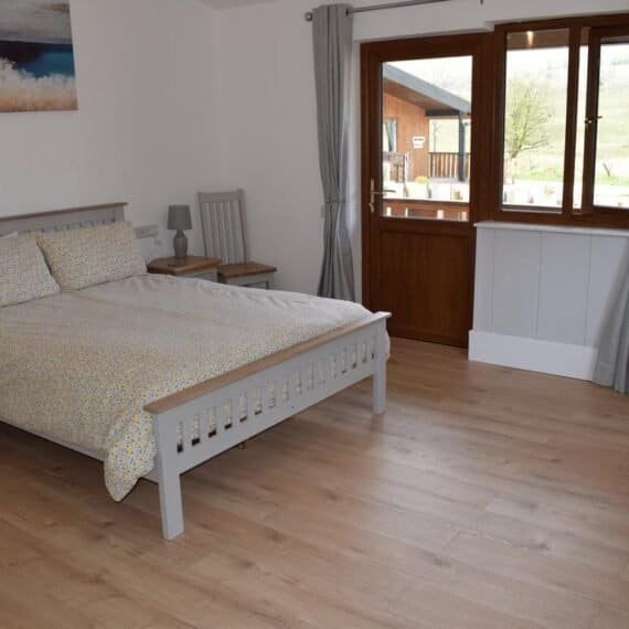 Bedroom with wooden bed and open door to balcony