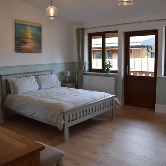 Cozy bedroom with wooden bed and balcony doors
