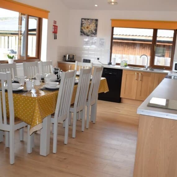 Bright dining room with white chairs and yellow accents