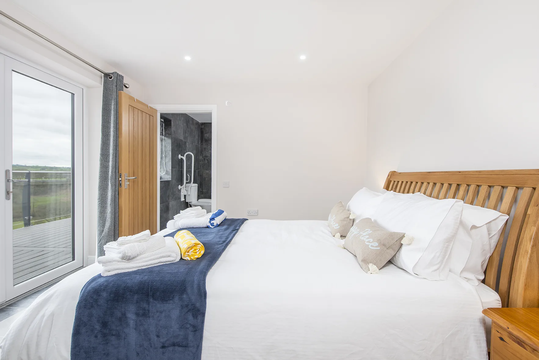Bright bedroom with wooden bed and open balcony door