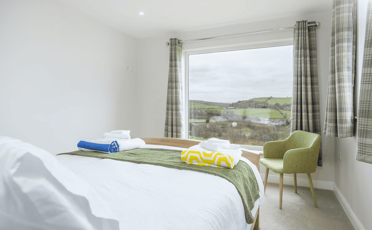 Bright bedroom overlooking scenic green hills