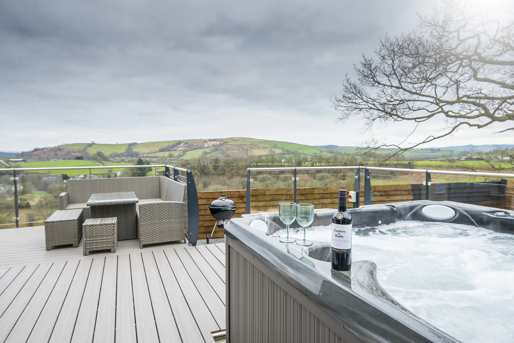 Outdoor hot tub with scenic hills view and wine