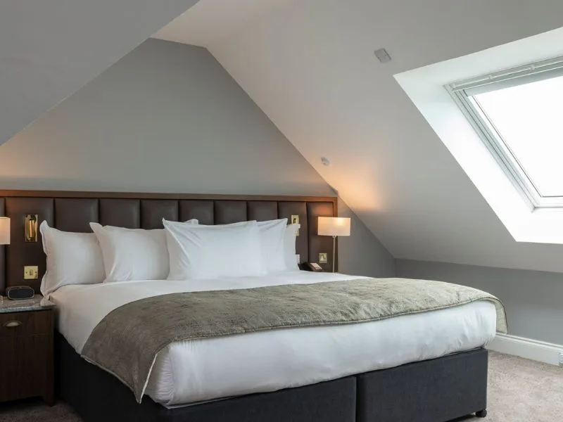 Cozy modern attic bedroom with skylight and plush bedding