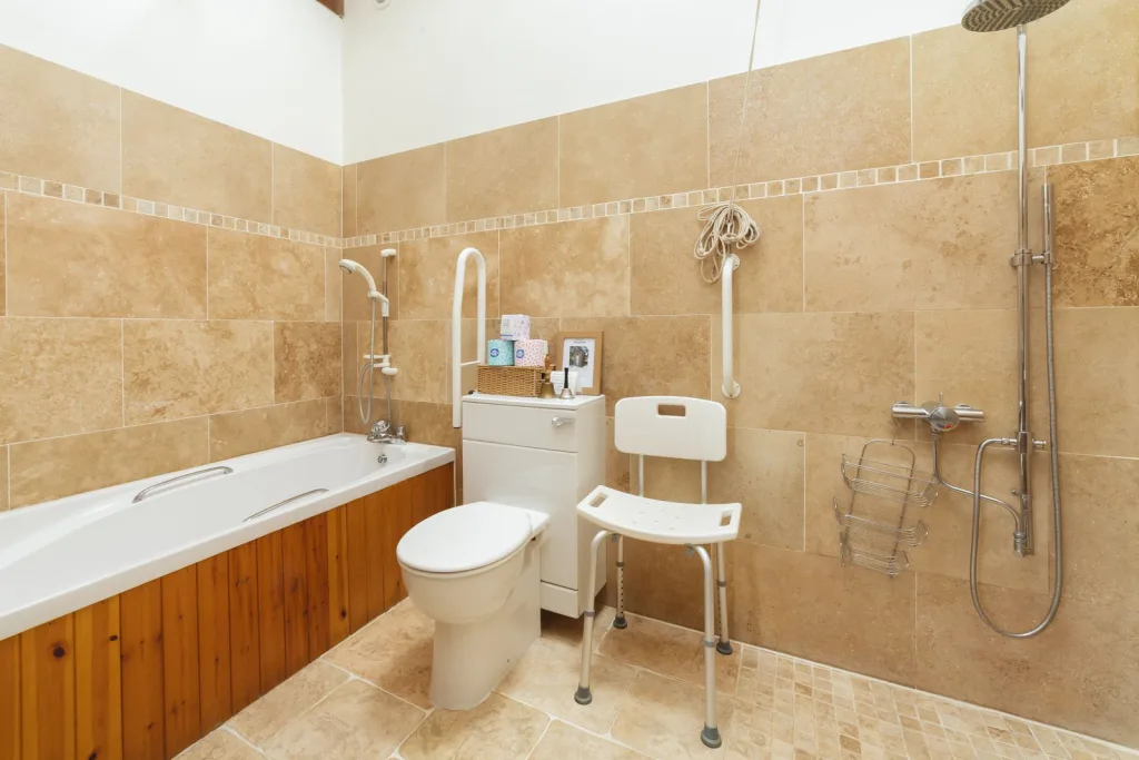 Accessible bathroom with safety features and neutral tiles