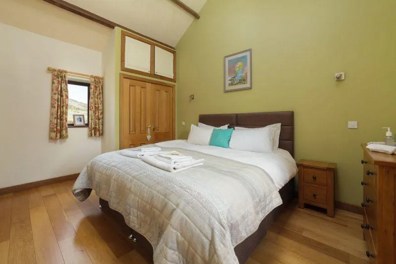 Cozy bedroom with wooden furnishings and green walls