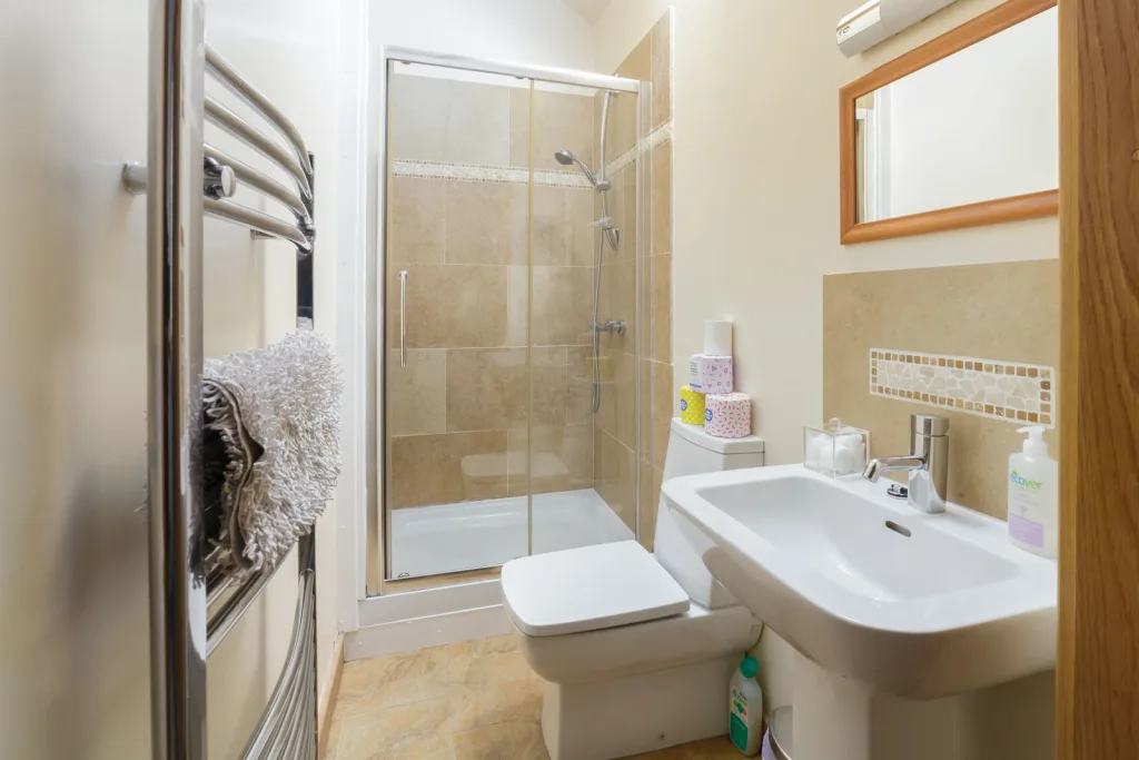Modern clean bathroom with shower and beige tiles