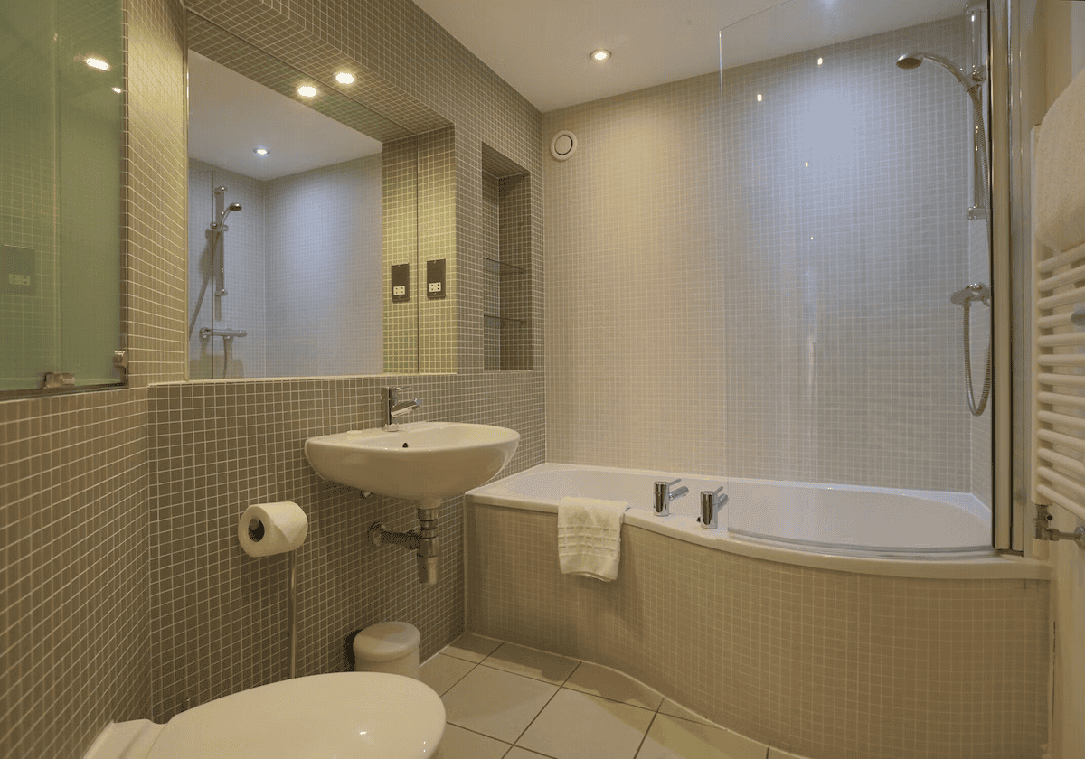 Modern bathroom with shower, tub, and mosaic tiles.