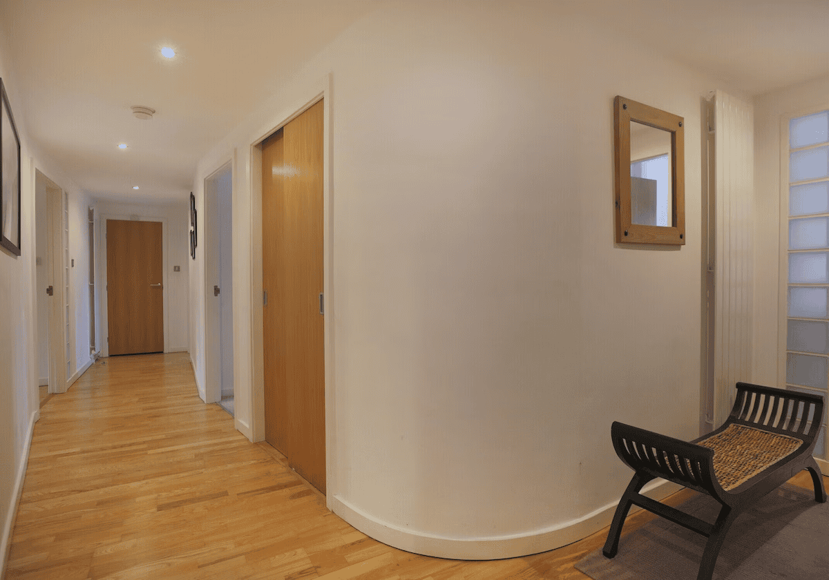 Bright hallway with wooden doors and bench