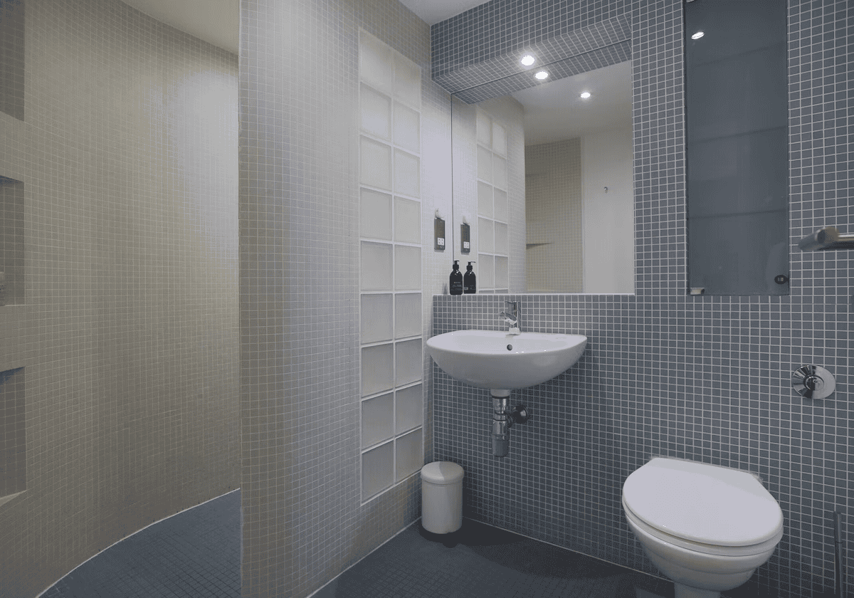 Modern bathroom with blue tiled walls and white fixtures