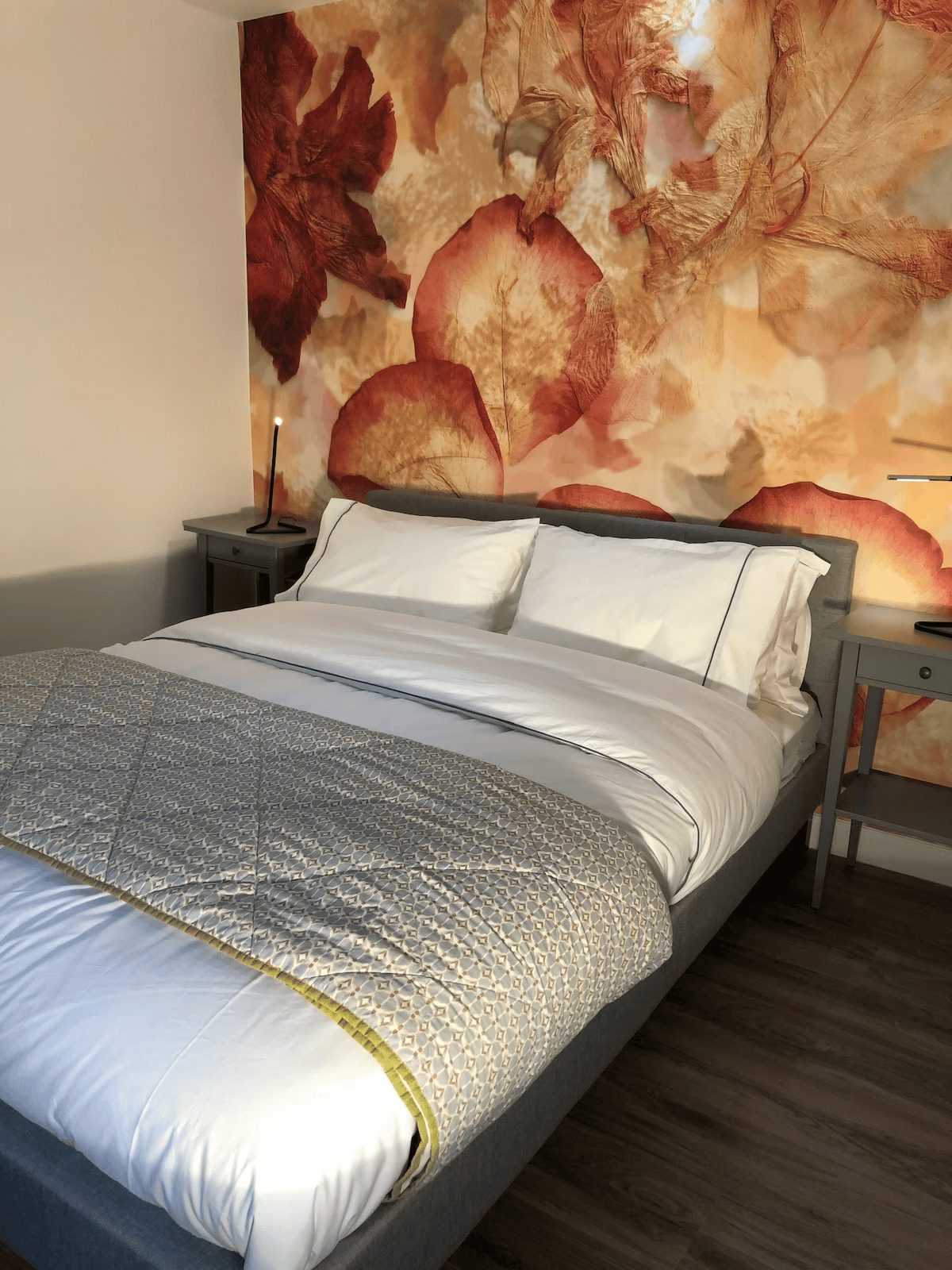 Modern bedroom with large floral wall art and cozy bedding