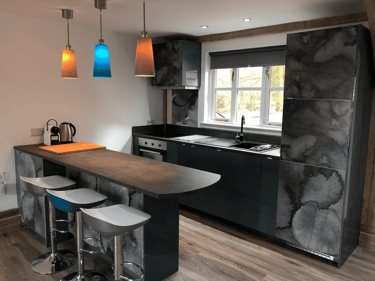 Modern kitchen with colorful pendant lights and bar stools