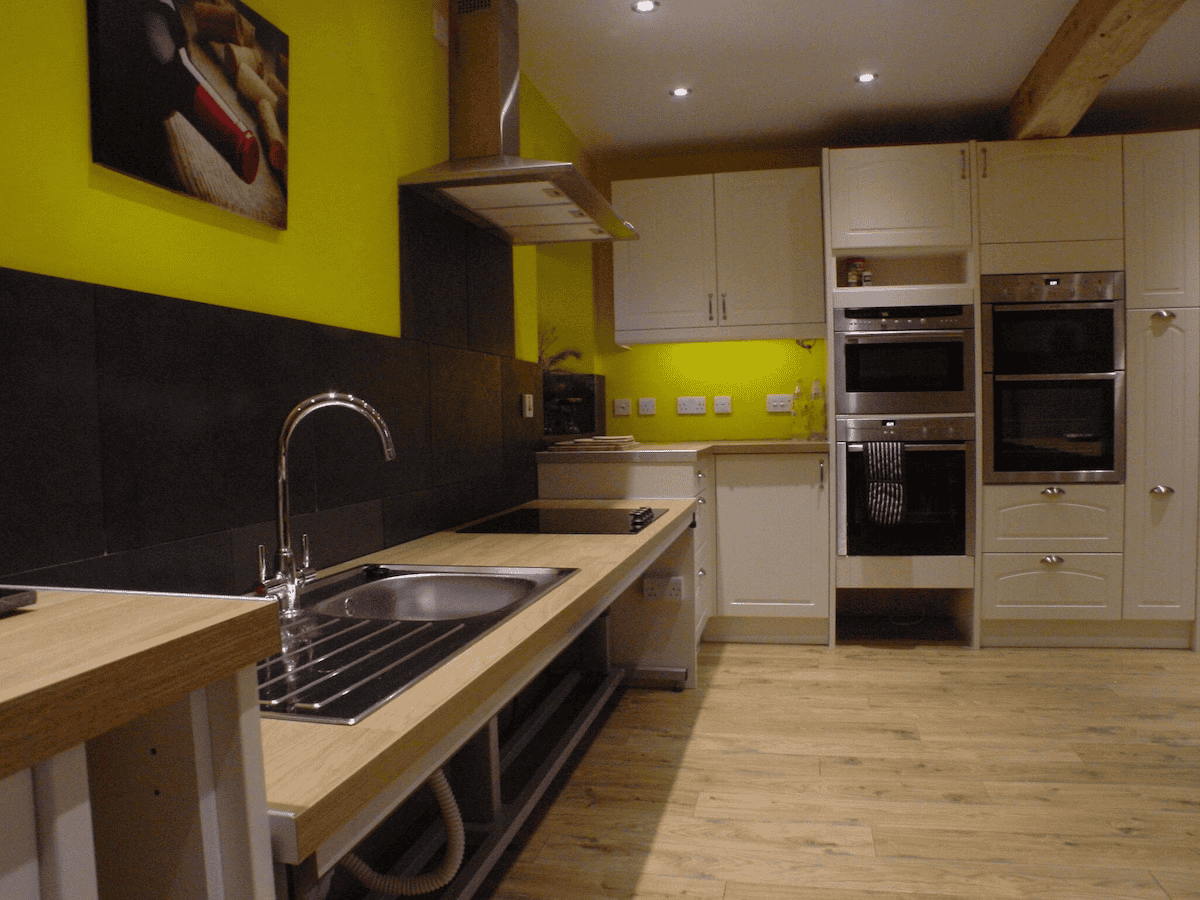 Modern kitchen with yellow walls and wooden accents