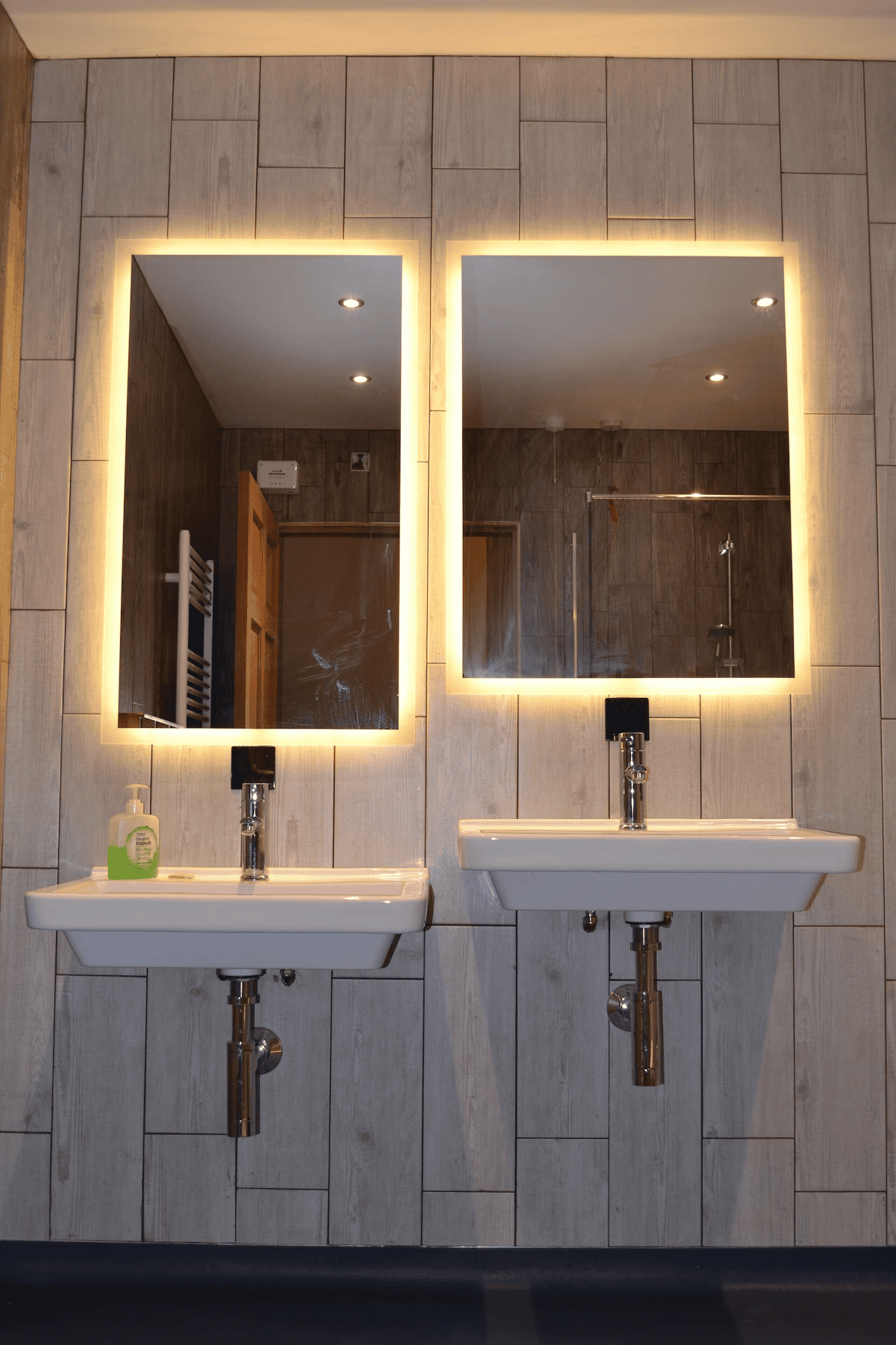 Modern bathroom with twin sinks and illuminated mirrors