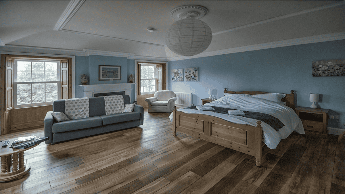 Spacious bedroom with wooden bed and blue walls