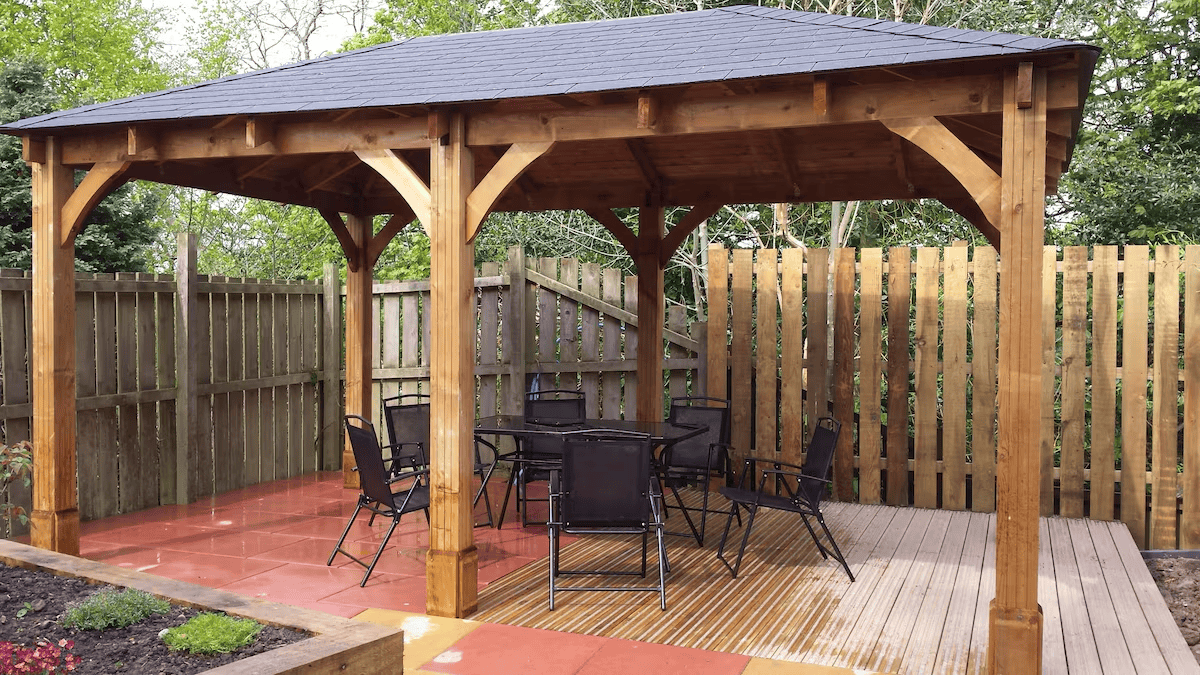Wooden gazebo with dining set in garden